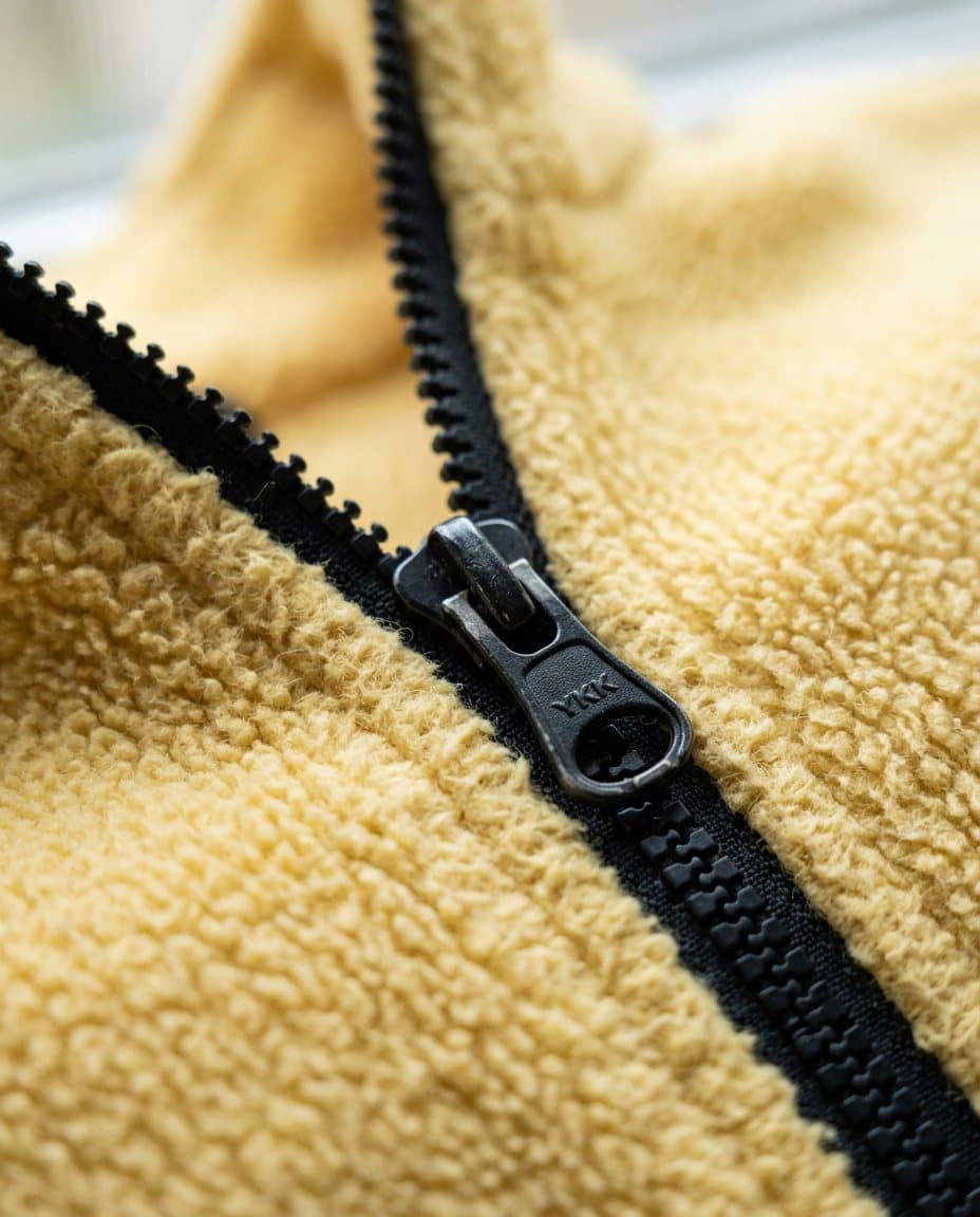 Detail bahan polar fleece kuning dengan resleting hitam